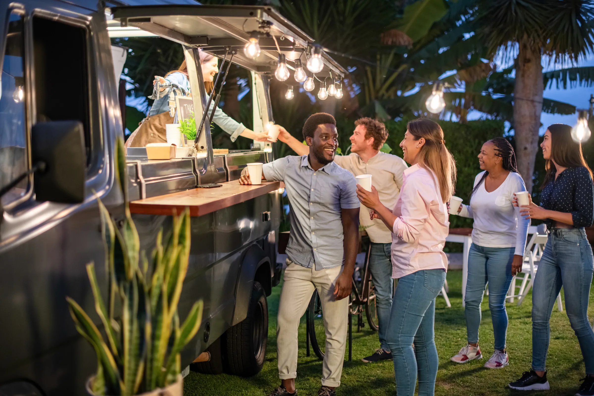 Gäste feiern am Foodtruck mit Lichterkette